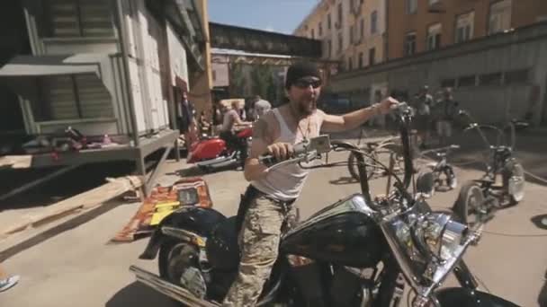 MOSCÚ, RUSIA - 27 DE JULIO DE 2015: Motero barbudo con gafas de sol en motocicleta negra. Día soleado de verano. Reunión de ciclistas — Vídeos de Stock