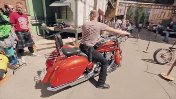 MOSCÚ, RUSIA - 27 DE JULIO DE 2015: Motociclista en gafas de sol en motocicleta naranja brillante. Día soleado de verano. Reunión de ciclistas — Vídeo de stock