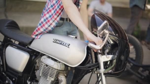 Moskva, Ryssland-27 juli 2015: ung Biker i Cap start Grey motorcykel. Sommar solig dag. Kameran hänger på halsen. Bikers möte — Stockvideo
