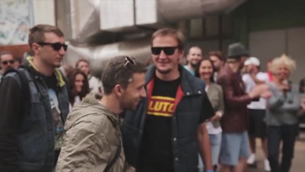 Москва, Росія-27 липня 2015: двоє молодих людей дурнем, приходять, щоб господар дати йому рукостискання. Літній вечір. Лотереї. Переможець — стокове відео