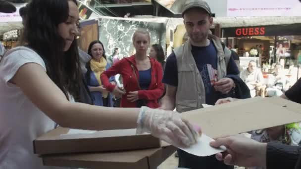 俄罗斯圣彼得堡-2016 年 6 月 4 日 ︰ 女孩给出多彩的甜甜圈到购物中心的人。公平。糖果. — 图库视频影像