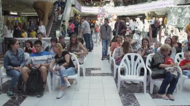 Petersburg, Rosja - 4 czerwca 2016 r.: Wielu ludzi siedzi na krzesłach w hali centrum handlowego. Odbiorcy zdarzeń. Słońce — Wideo stockowe