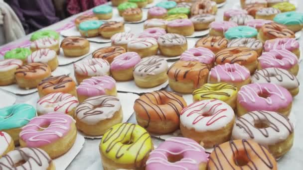 SAINT PETERSBURG, RUSSIE - 4 JUIN 2016 : Table blanche servie avec de nombreux beignets colorés. Produit de boulangerie. La foule des gens — Video