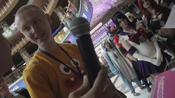 SAN PETERSBURG, RUSIA - 4 DE JUNIO DE 2016: Hombre con micrófono habla con niño de camisa amarilla. Lotería en el centro comercial — Vídeos de Stock