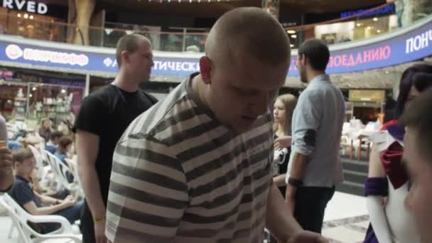 СЕНТ-ПЕТЕРСБУРГ, РОССИЯ - 4 июня 2016 года: Человек с микрофоном. Мужчина открывает лотерейный мяч. Торговый центр. Многие люди . — стоковое видео