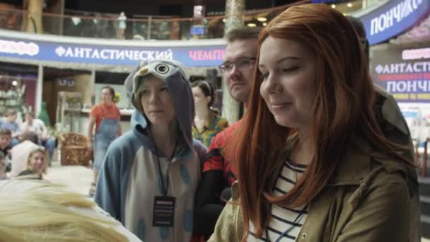 Санкт-Петербург, Росія-4 червня 2016: дівчата в барвистих костюмах хвиля руками в камері в торговому центрі серед інших — стокове відео
