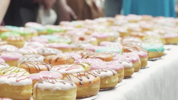 Sint-Petersburg, Rusland-4 juni 2016: witte tafel geserveerd met kleurrijke donuts. Bakkerijproducten. Snoep. Mensen — Stockvideo