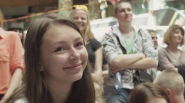 Saint Petersburg, Rusya - 4 Haziran 2016: Sevimli kız alışveriş merkezinde diğer insanlar arasında otur. Eğlence etkinliği. Gülümseme