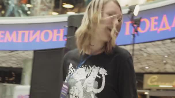Saint petersburg, russland - 4. juni 2016: jugendliche blonde mädchen spielen auf unsichtbarer gitarre im einkaufszentrum. Meisterschaft. — Stockvideo