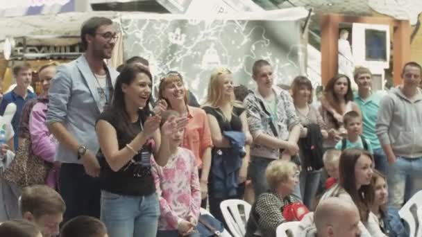 SAN PETERSBURG, RUSIA - 4 DE JUNIO DE 2016: Feliz niña y hombre aplauden en el centro comercial entre la gente. Evento de entretenimiento — Vídeos de Stock