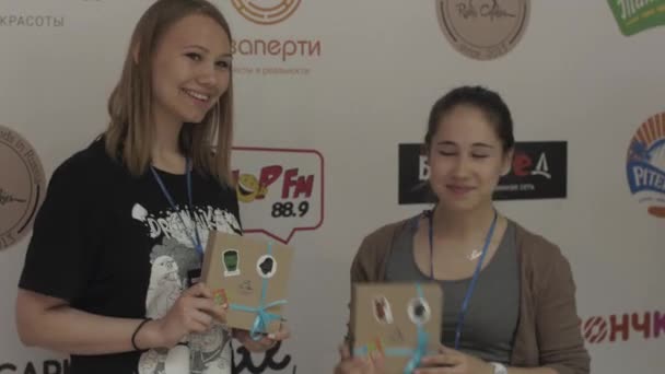 SAINT PETERSBURG, RUSSIA - JUNE 4, 2016: Girls posing with gift boxes at stand. Entertainment event in shopping center — Stock Video