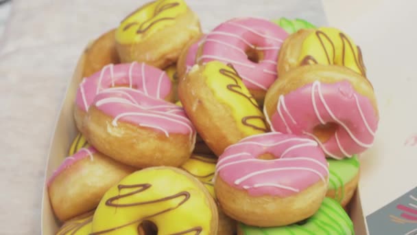 SAN PETERSBURG, RUSIA - 4 DE JUNIO DE 2016: Cajas con muchas rosquillas apetitosas cubiertas de esmalte sobre la mesa. Panadería. Gente — Vídeos de Stock