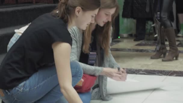 SAINT PETERSBURG, RUSSIA - 4 GIUGNO 2016: Le ragazze disegnano poster con pennarello nel centro commerciale al piano. Evento di intrattenimento — Video Stock