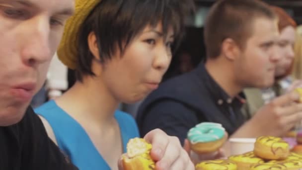 상트페테르부르크, 러시아-6 월 4 일, 2016: 사람들이 속도에 테이블에서 다채로운 맛 있는 도넛을 먹는다. 에 도전 합니다. 선수권 대회 — 비디오