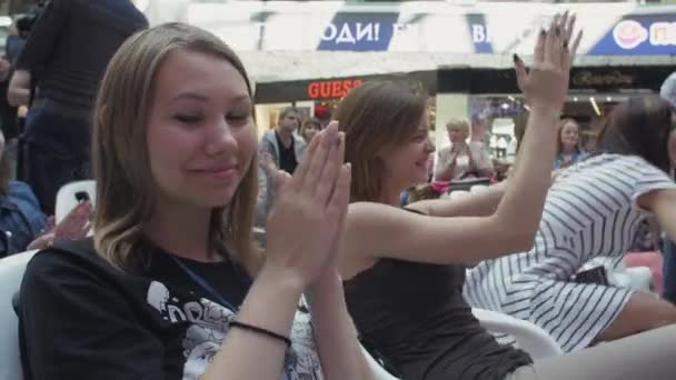 SAINT PETERSBURG, RUSSIA - JUNE 4, 2016: Gadis duduk di kursi dan bertepuk tangan di pusat perbelanjaan antara orang lain. Rangkaian . — Stok Video