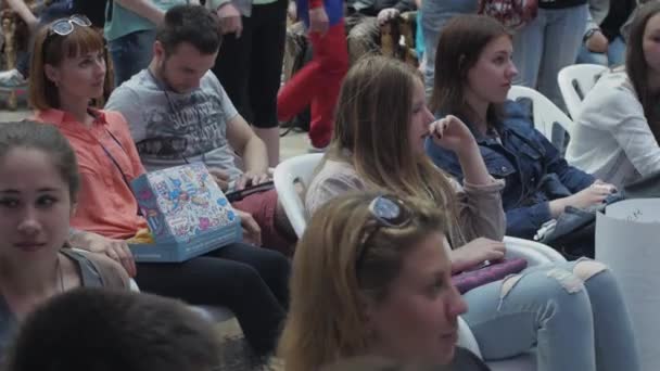 SAINT PETERSBURG, RUSSIA - 4 GIUGNO 2016: Persone sedute sulla sedia, ragazza che tiene la scatola con le ciambelle. Evento di intrattenimento — Video Stock