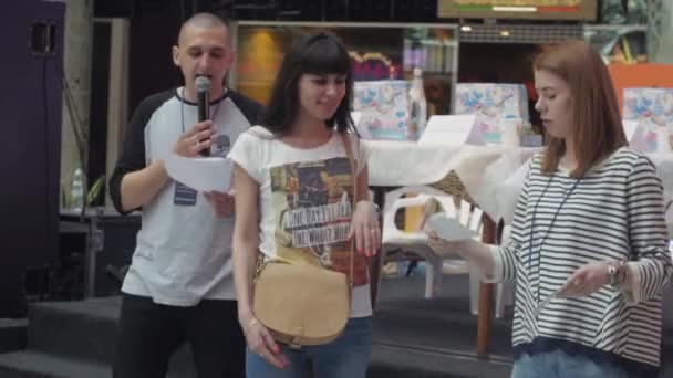 SAN PETERSBURG, RUSIA - 4 DE JUNIO DE 2016: Mujer dar cupón a la niña con en el centro comercial. Pose para la foto. Entretenimiento — Vídeos de Stock