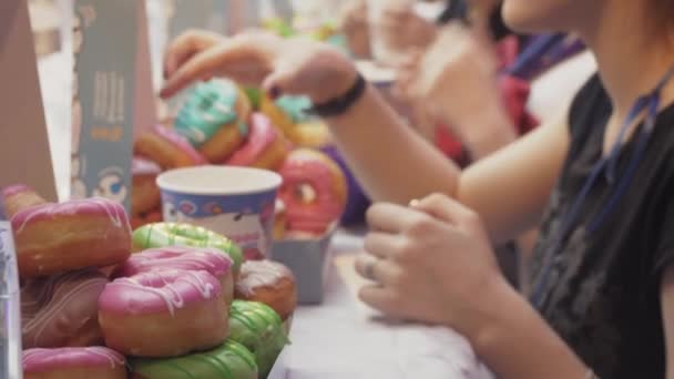 상트페테르부르크, 러시아-6 월 4 일, 2016: 사람들이 준비 속도에 테이블에서 유약으로 덮여 도넛을 먹고. 선수권 대회 — 비디오