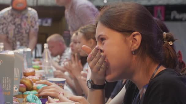 SAINT PETERSBURG, RUSSIA - 4 GIUGNO 2016: La gente mangia ciambelle a tavola a velocità. Campionato. Ragazza con la bocca piena. Sorridi — Video Stock