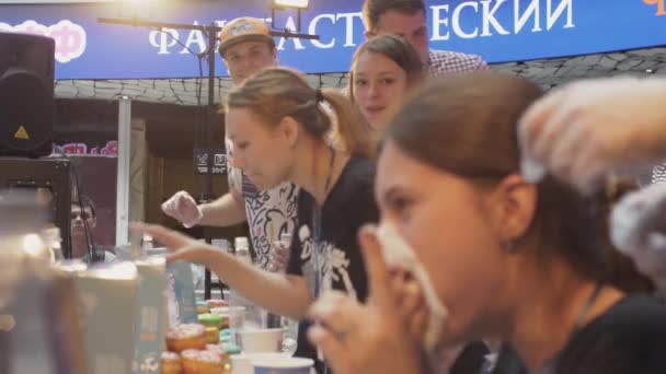 Sankt Petersburg, Ryssland - 4 juni 2016: Människor äter munk vid bord på hastighet. Mästerskapet. Flicka skratta med full mun. — Stockvideo