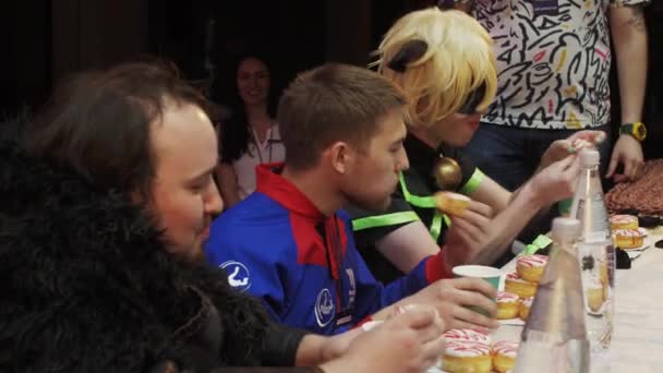 Sankt Petersburg, Ryssland - 4 juni 2016: Tre män i kostymer äta munkar vid bord på hastighet. Utmaningen. Mästerskapet. — Stockvideo