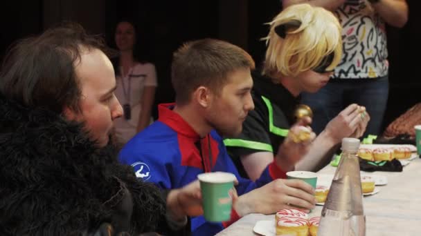 SAINT PETERSBURG, RUSSIA - 4 GIUGNO 2016: Tre uomini in costume mangiano ciambelle a tavola sulla velocità. Concorso. Campionato . — Video Stock