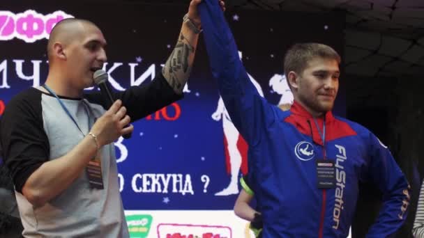 SAN PETERSBURG, RUSIA - 4 DE JUNIO DE 2016: Hombre con micrófono levanta la mano del ganador del campeonato. Centro comercial. Cuenco — Vídeo de stock