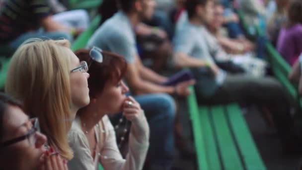 MOSCOU, RUSSIE - 23 AOÛT 2011 : Trois filles assises sur un banc vert lors d'un concert estival en direct entre autres. Fumer la cigarette . — Video
