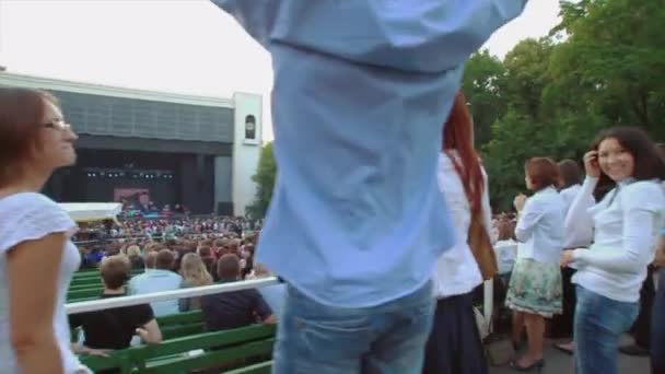 俄罗斯莫斯科-2011 年 8 月 23 日 ︰ 背侧的人在夏天现场直播的音乐会。乐队在舞台上表演。人群。跳跃 — 图库视频影像
