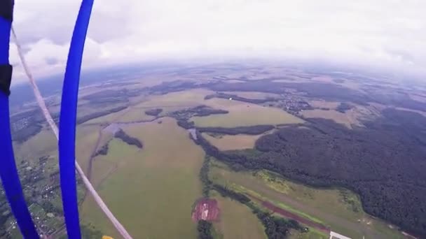 Скайдайвер летает на парашюте над зелеными полями. Большая высота. Летний день. Мбаппе — стоковое видео