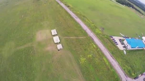 Skydiver vliegen op parachute landing op groene veld. Zomerdag. Extreme sporten — Stockvideo