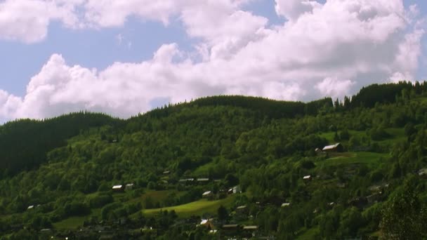 Panoramisch uitzicht stad op bergen bedekt groene bossen in zonnige zomerdag. Wolk drift. Natuur — Stockvideo