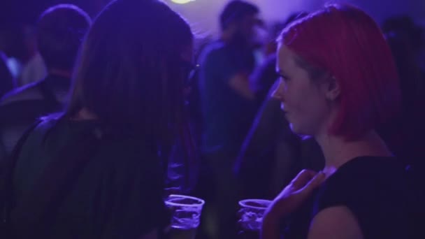 SAN PETERSBURG, RUSIA - 26 DE JUNIO DE 2015: Dos chicas con vasos de cerveza en la discoteca de la discoteca. Proyectores. Animando. Concierto en vivo — Vídeos de Stock