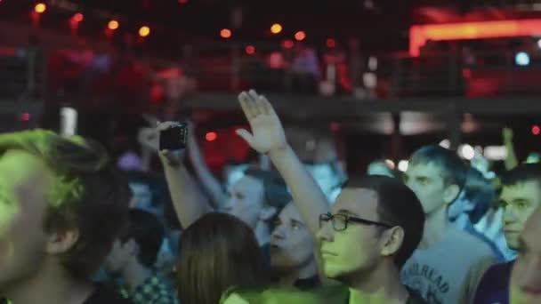 SAN PETERSBURG, RUSIA - 26 DE JUNIO DE 2015: Multitud de jóvenes levantan la mano, saltan a la discoteca en la discoteca. Proyectores. Animando. Concierto — Vídeos de Stock