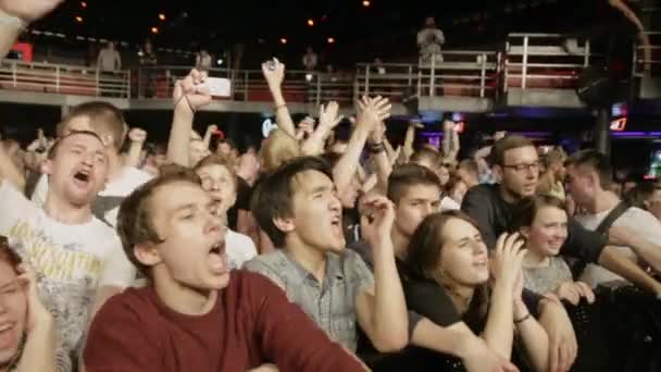 SAINT PETERSBURG, RUSSIA - JUNE 26, 2015: Crowd of young people scream, sing, raise hands on discotheque in nightclub. Spotlights. Cheering. — Stock Video