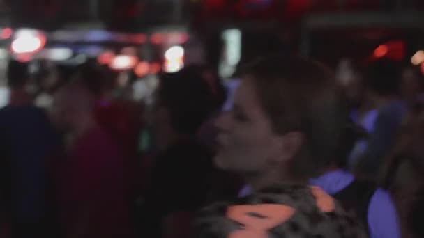SAN PETERSBURG, RUSIA - 26 DE JUNIO DE 2015: Mujer joven bailando torpemente en discoteca en discoteca entre otras personas. Proyectores . — Vídeo de stock