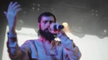 Saint Petersburg, Rusya - 26 Haziran 2015: Halk gömlekli sakallı şarkıcı, diskotek gece kulübünde sahneye bast ayakkabı gerçekleştirin. Sahne ışıkları