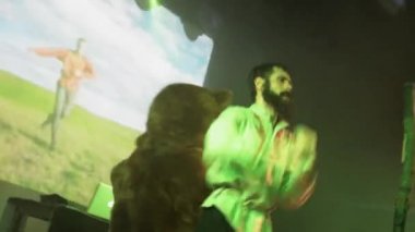 Saint Petersburg, Rusya - 26 Haziran 2015: Vokalist halk gömlekli adam manto, kostüm ayı kalabalık gece kulübünde sahnede. Sahne ışıkları.