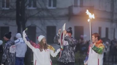 Saint Petersburg, Rusya - 27 Ekim 2013: Ekim ayında St. Petersburg'da bayrak yarışı Olimpiyat ateşi. Meşale taşıyıcısı kadına meşale yak. Dalga el