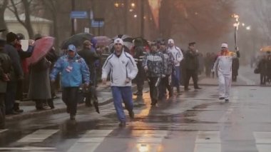 Saint Petersburg, Rusya - 27 Ekim 2013: Ekim ayında St. Petersburg'da bayrak yarışı Olimpiyat ateşi. Meşale taşıyıcısı alevle koşar. Yağmur. Muhafız