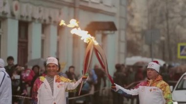 Saint Petersburg, Rusya - 27 Ekim 2013: St. Petersburg'da bayrak yarışı Olimpiyat ateşi. Meşale taşıyıcısı mutlu Bari Alibasov için alev geçmek.