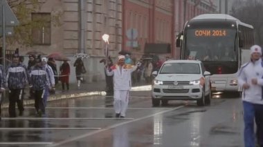 Saint Petersburg, Rusya - 27 Ekim 2013: Ekim ayında St. Petersburg'da bayrak yarışı Olimpiyat ateşi. Bari Alibasov alev, dalga el ile koşmak.