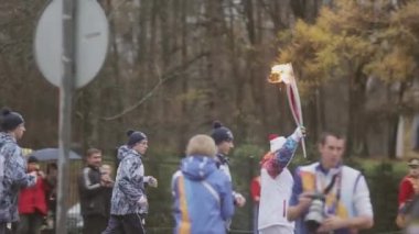 Saint Petersburg, Rusya - 27 Ekim 2013: bayrak yarışı Olimpiyat alev Peterhof, Saint Petersburg içinde. Alev ile çalıştırmak ışık tutan kimse. Törenleri. Otobüs