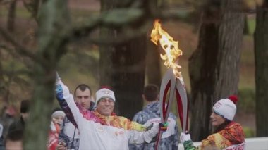Saint Petersburg, Rusya - 27 Ekim 2013: Peterhof, St. Petersburg'da bayrak yarışı Olimpiyat ateşi. Kadın meşale taşıyıcısı parkta adama alev geçmek