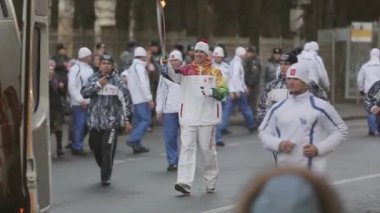 Saint Petersburg, Rusya - 27 Ekim 2013: St. Petersburg'da bayrak yarışı Olimpiyat ateşi. Erkek meşale taşıyıcısı alevle koşar. Muhafız. Seyirci