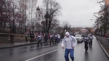 Saint Petersburg, Rusya - 27 Ekim 2013: St. Petersburg'da bayrak yarışı Olimpiyat ateşi. Kadın meşale taşıyıcısı alevle koşar. Kortej. Otobüs