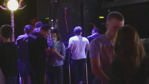 SAN PETERSBURG, RUSIA - 26 DE JUNIO DE 2015: Los adolescentes se quedan en la discoteca. Preparación antes del concierto en vivo. Proyectores. Citas parejas — Vídeos de Stock