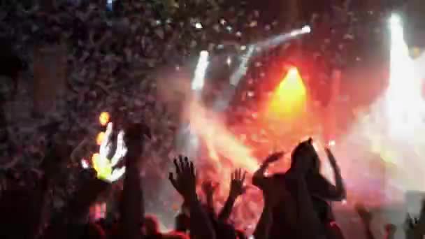 СЕНТ-ПЕТЕРБУРГ, РОССИЯ - 26 ИЮНЯ 2015: Люди танцуют в ночном клубе. Прожекторы. Фолк-рок группа выступает на сцене. Конфетти. Балалайка — стоковое видео