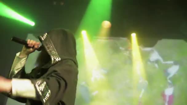 САЙНТ-ПЕТЕРБУРГ, РОССИЯ - 26 июня 2015 года: Бородатый вокалист в мантии выступает на сцене в ночном клубе. Зеленые прожекторы. Живое выступление — стоковое видео