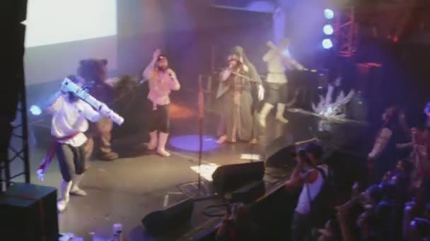SAINT PETERSBURG, RUSIA - 26 DE JUNIO DE 2015: Banda de música folk rock que actúa en el escenario de una discoteca. Proyectores. Hombre disparar confeti en multitud — Vídeos de Stock